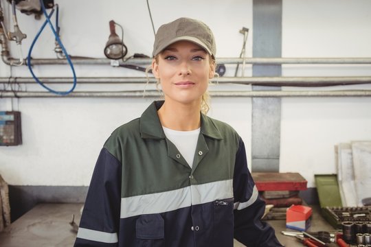 Portrait of beautiful female mechanic in garage