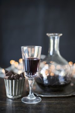 Port wine in a glass and a carafe with chocolate pralines