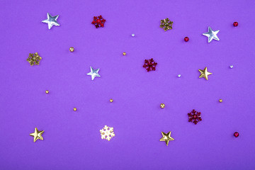 Red, yellow and green heart and circle confetti on a purple background.