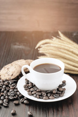 Coffee cup and coffee beans on wooden background