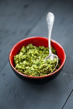 Wild garlic pesto in a red bowl on a wooden surface