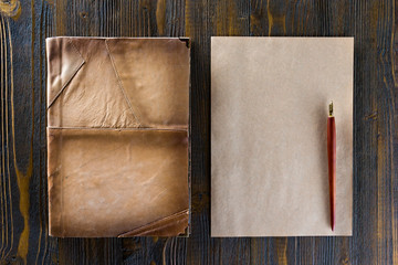 Mockup of vintage blank letterhead and diary with leather cover at wooden table background.