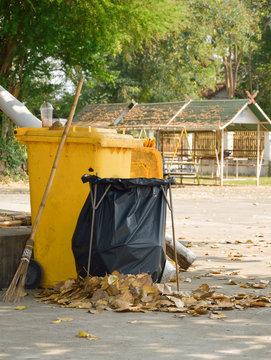 Yellow garbage bin and black garbage bag, Bo leaves fall to the ground