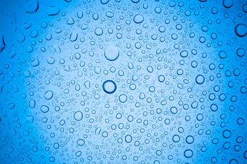 Rain droplets on blue glass background, Water drops on glass.