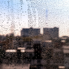 Rain / Water drop of rain on glass with blured cityscape, outdoor background and texture
