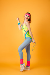 Smiling young fitness with jumping rope woman standing and posing