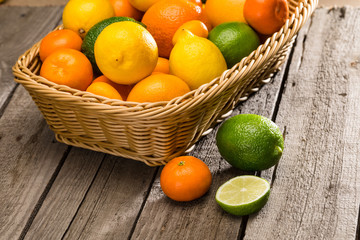 Close-up view of fresh ripe citrus fruits in basket on wooden table
