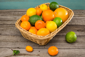 Fototapeta na wymiar Close-up view of fresh ripe citrus fruits in basket on wooden table