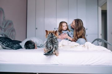 Mother, father,and baby on the bed