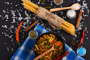 Dried colorful italian pasta on blue plaid tablecloth