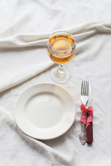 Tableware, white plate, fork, knife, juice on a white tablecloth