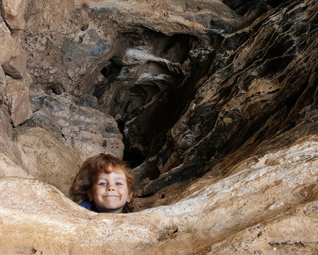 6 year old kid look out from cave