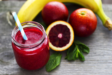 Red smoothie with red oranges, apples, pomegranate and mint