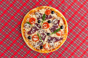 fresh pizza in a rustic Italian style with jerky olives mushrooms and three kinds of cheese on a light wooden background
