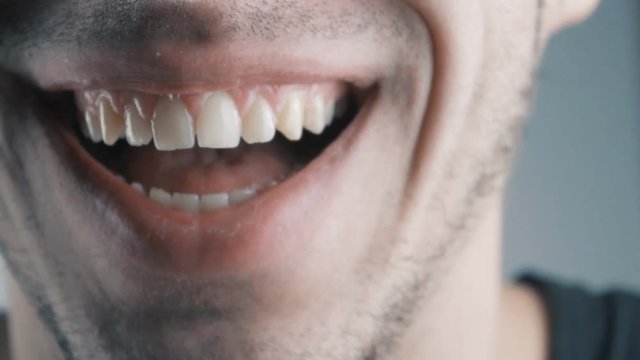 Young man laughing. Closeup on his mouth.