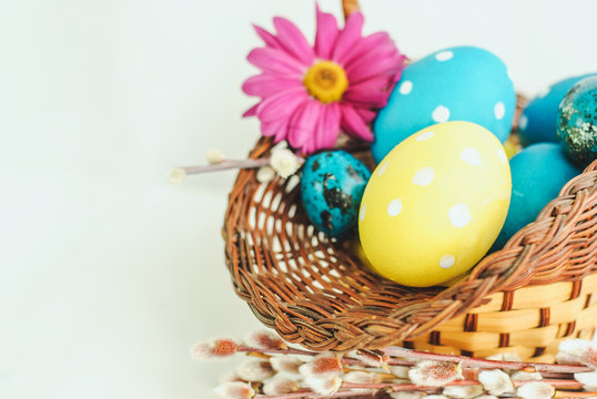 colorful easter eggs in a basket on white background