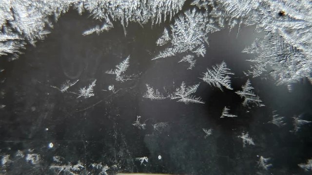 little frozen patterns appear on glass with water dew