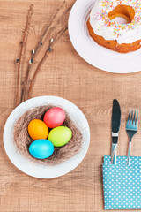 Festive table with colorful  eggs and  cupcake