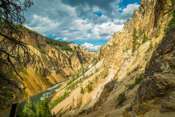 Obraz premium The stormy river flows in a narrow gorge in the rocks. Uncle Toms Trail on The Grand Canyon of the Yellowstone National Park, Wyoming