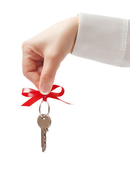 Hand holding key with bow isolated on white background