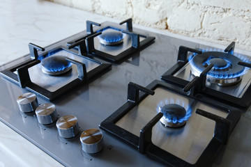 Cooktop with burning gas ring. Gas cooker with blue flames.