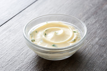 Aioli sauce in bowl on wooden background
