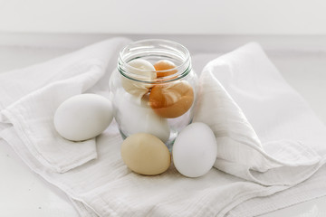 Fototapeta na wymiar chicken eggs in a jar on a white napkin