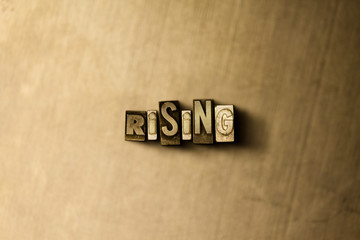 RISING - close-up of grungy vintage typeset word on metal backdrop. Royalty free stock illustration.  Can be used for online banner ads and direct mail.