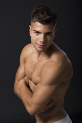 Fototapeta premium Handsome muscular young man posing in the studio