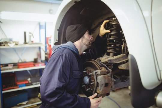 Mechanic examining a car wheel disc brake