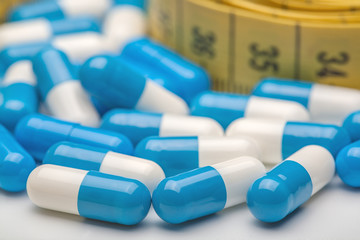 measuring tape and medicines on white background