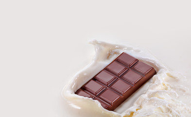 Chocolate falling into splashing milk. Isolated on white. High resolution photo.