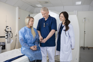 Obraz premium Professional With Colleague And Patient Using Computer Before MR