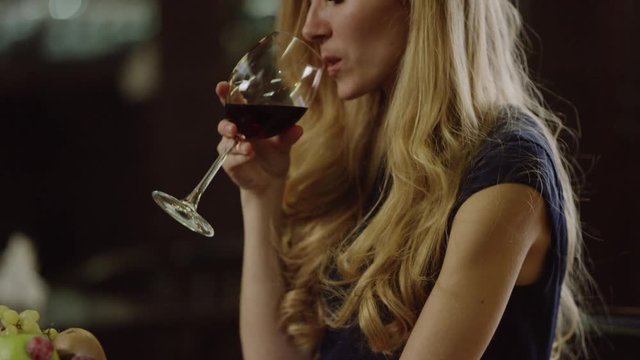 blondie woman drinking red wine in cafe
