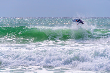 Naklejka premium Surfer riding a huge wave during World surf league competition in Lacanau, France