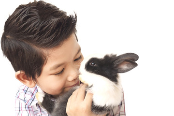 Asian kid playing with lovely baby rabbit isolated over white