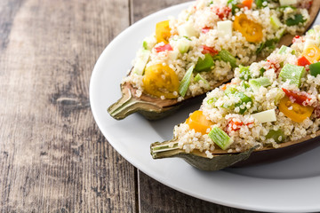 Stuffed eggplant with quinoa and vegetables on wooden background
