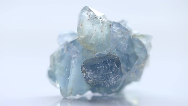 one pale blue stone Celestite (Celestine ) on a white blurred background