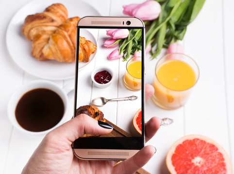 Taking photo of delicious breakfast with smartphone