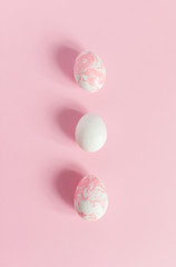 White Easter eggs on a light pink background