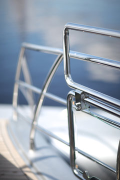 Fototapeta Shiny chrome metal fencing and railings yacht on the background of the smooth surface of the water