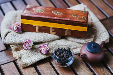 Black tea with dried flowers on wooden table