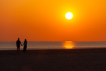 Fototapeta premium Liebes Paar beim Sonnenuntergang am Strand