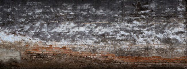 Background broken wall with dirty plaster and old brick.