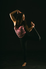 mujer joven latina realizando contorsiones, piruetas, gestos y acrobacias en un estudio con fondo...