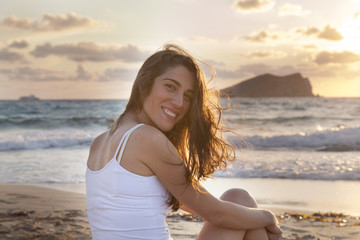 cheerful woman with incredible sunset in Ibiza isolated on the beach
