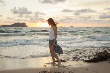 full body of romantic woman feelling free on a sunset beach in Ibiza