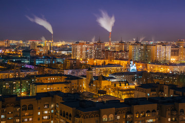 Obraz premium Night view of Voronezh from rooftop. Residential area and smoking pipes of factories 