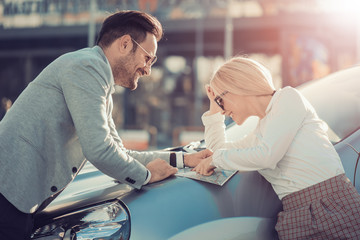 Smiling man and woman using map on roadtrip