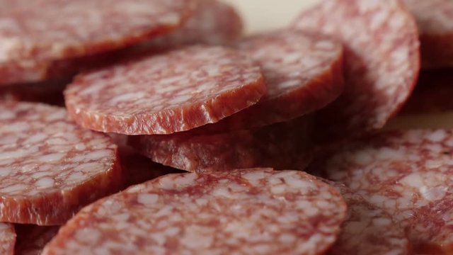 Salami smaller pieces on table 4K 2160p 30fps UltraHD tilting footage - Food background of cured sausage of air-dried meat cuts slow tilt 3840X2160 UHD video